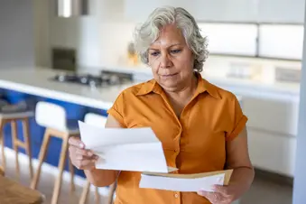 photo of older woman looking at medical bills