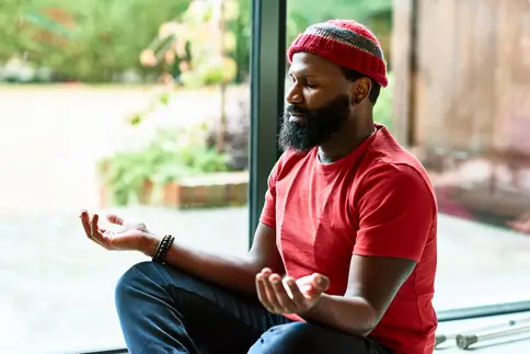 photo of man meditating at home