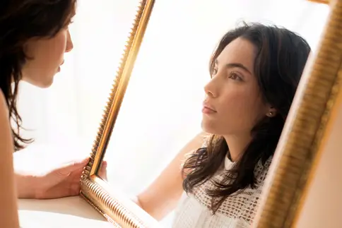 photo of serious woman looking in mirror