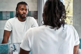 photo of serious man looking in mirror