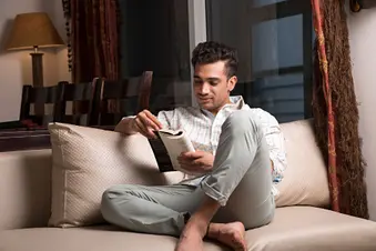 photo of man reading on couch