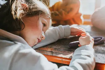 photo of unhappy child with head on school desk