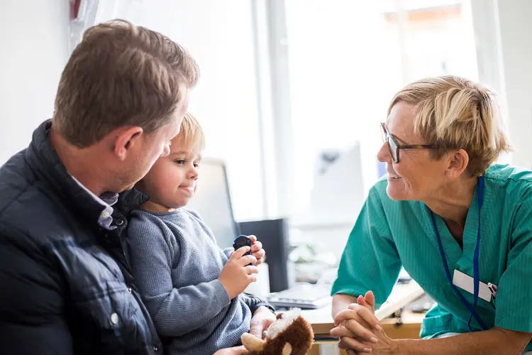 photo of friendly pediatrician talking with father and son