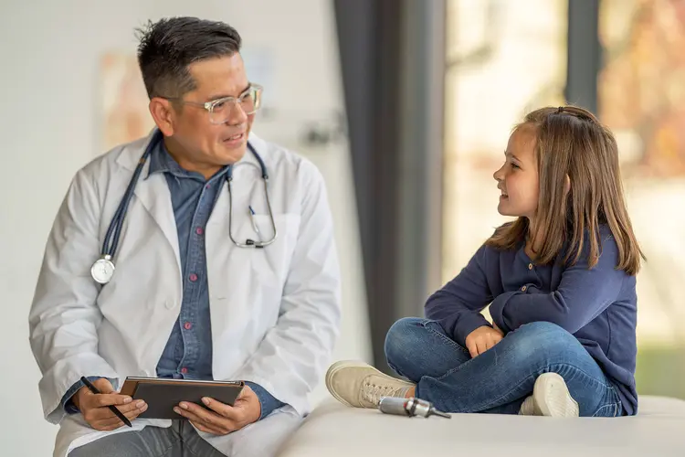 photo of young girl talking with pediatrician