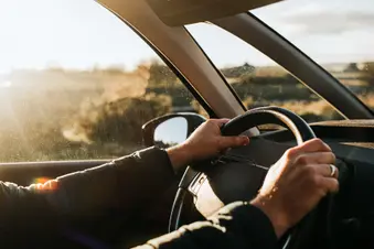 photo of hands on steering wheel while driving