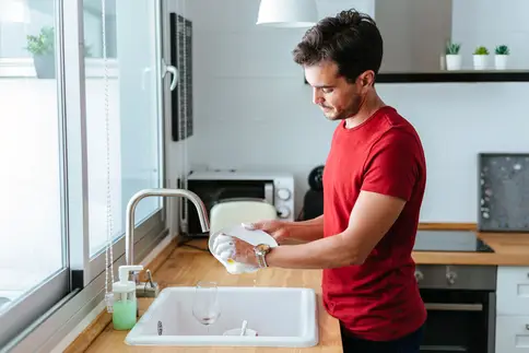 photo of man washing dishes at home