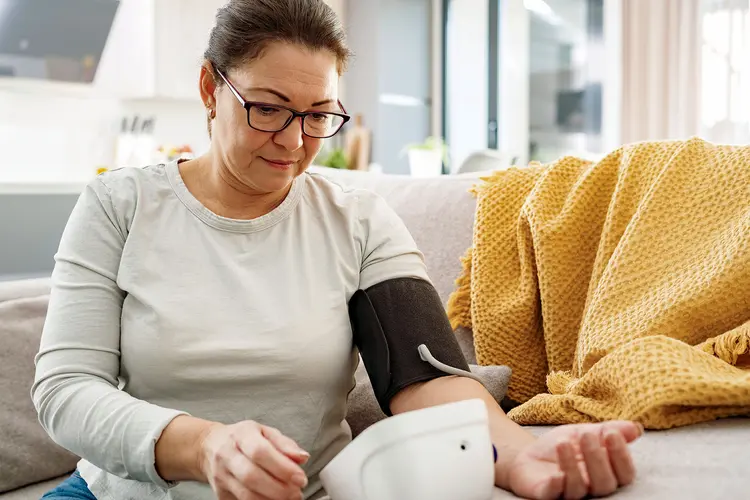 photo of woman with isolated systolic high blood pressure on sofa checking blood pressure