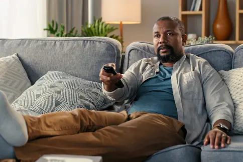 photo of man watching TV at home