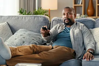 photo of man watching TV at home