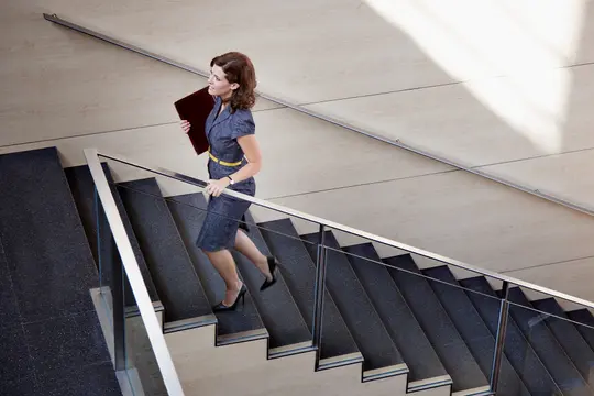 photo of businesswoman walking up stairs