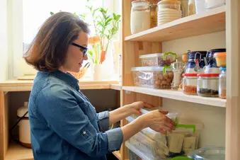 photo of woman organizing cabinet