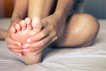 woman massaging foot close up