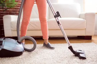 photo of woman vacuuming rug