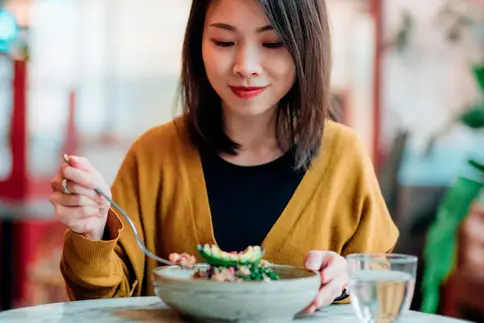 photo of woman eating salad