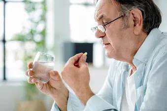photo of mature man taking pill